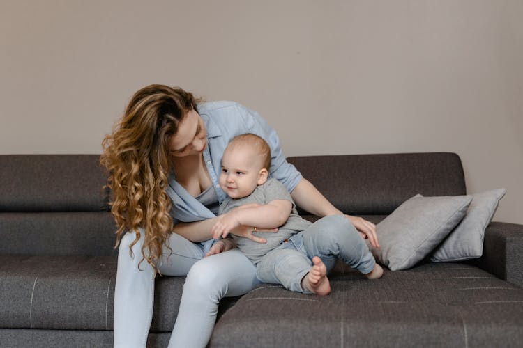 Woman And Baby Sitting On A Couch