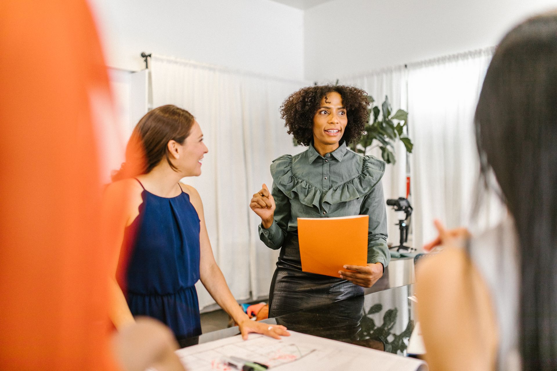 Diverse group of women engaged in a collaborative meeting in a modern office setting.