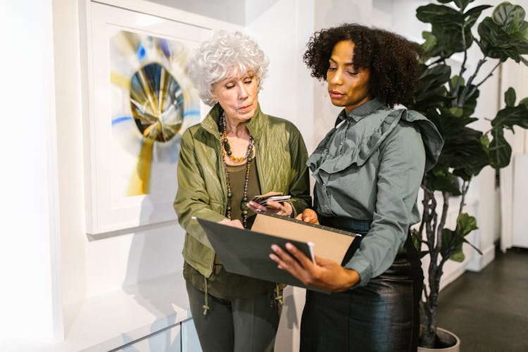 Women Discussing Their Work Inside The Office