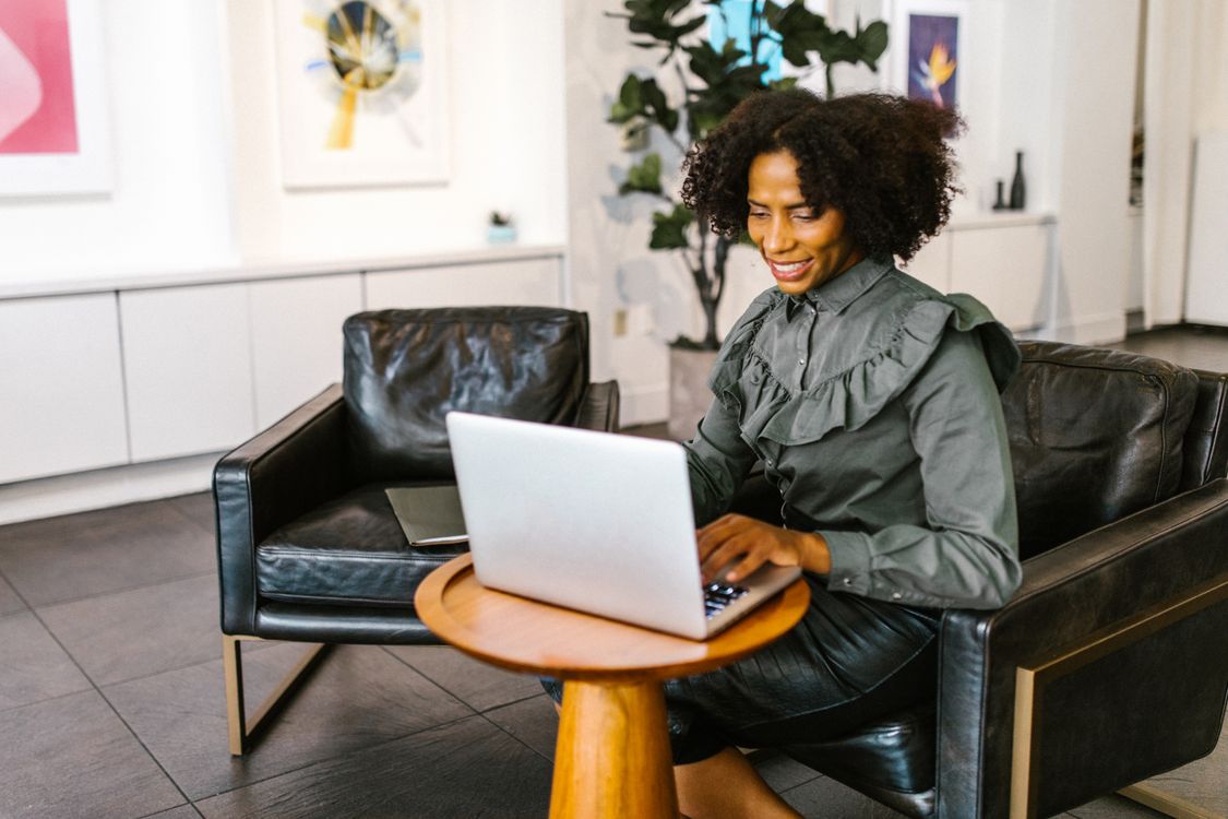 A smiling woman working on a laptop