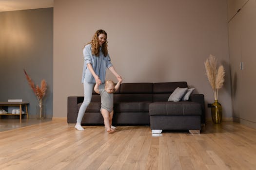Mother and baby walking hand in hand in a stylish living room.