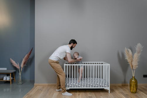 A Man Carrying His Baby on the Crib