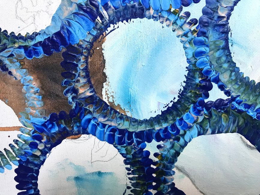 Vibrant abstract painting with blue circular patterns creating artistic texture and depth.