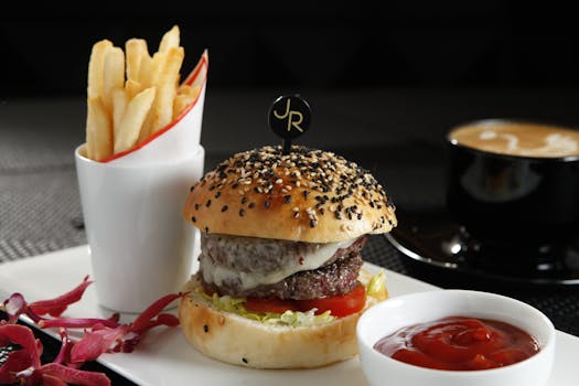 Appetizing gourmet burger with fries and coffee, perfect for a modern dining experience.