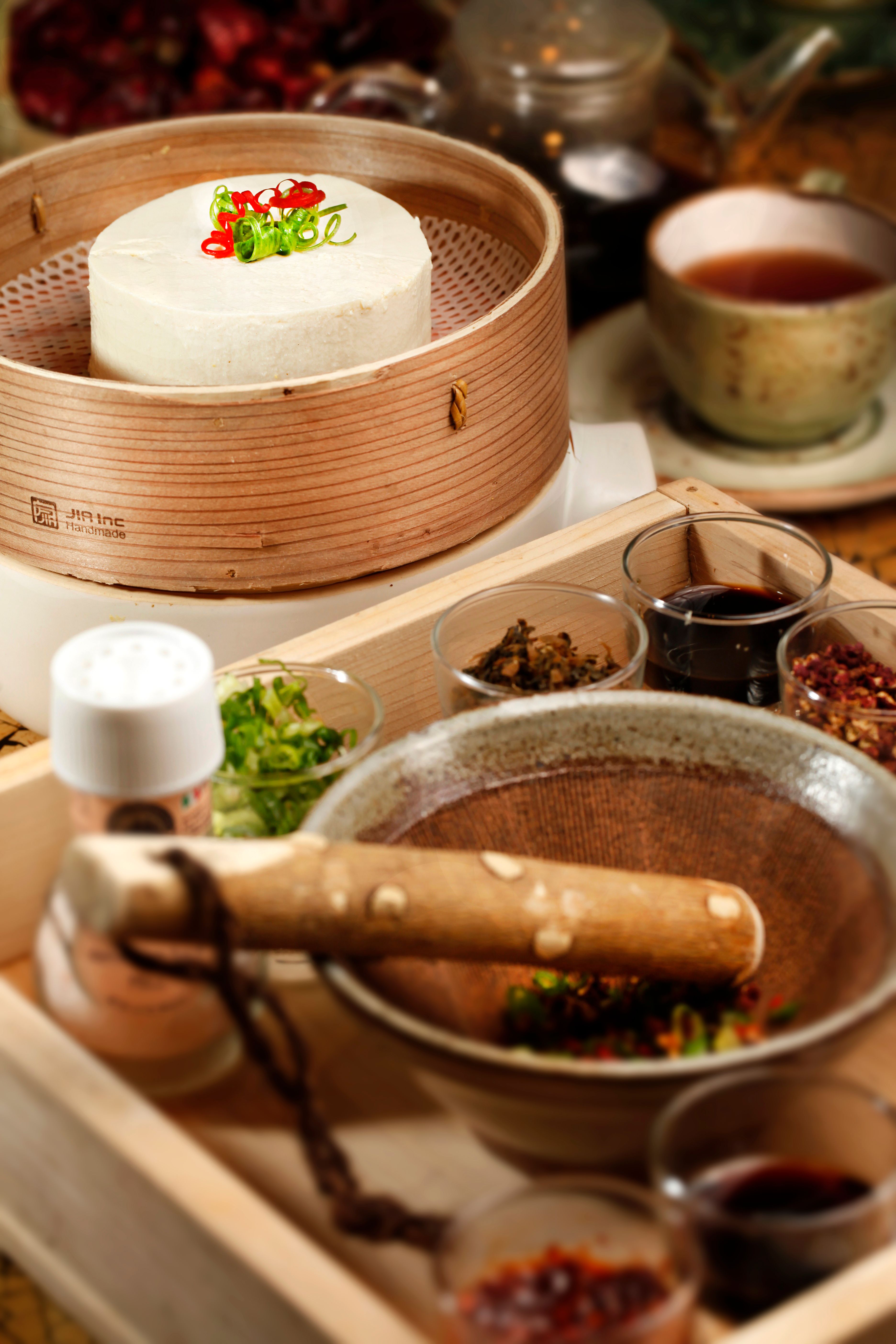 Close-up of Asian ingredients and tools for gourmet meal preparation in kitchen.