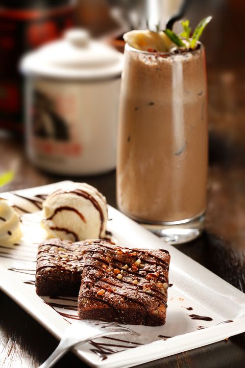 Free Rich chocolate brownies paired with ice cream and a creamy milkshake on a stylish plate. Stock Photo