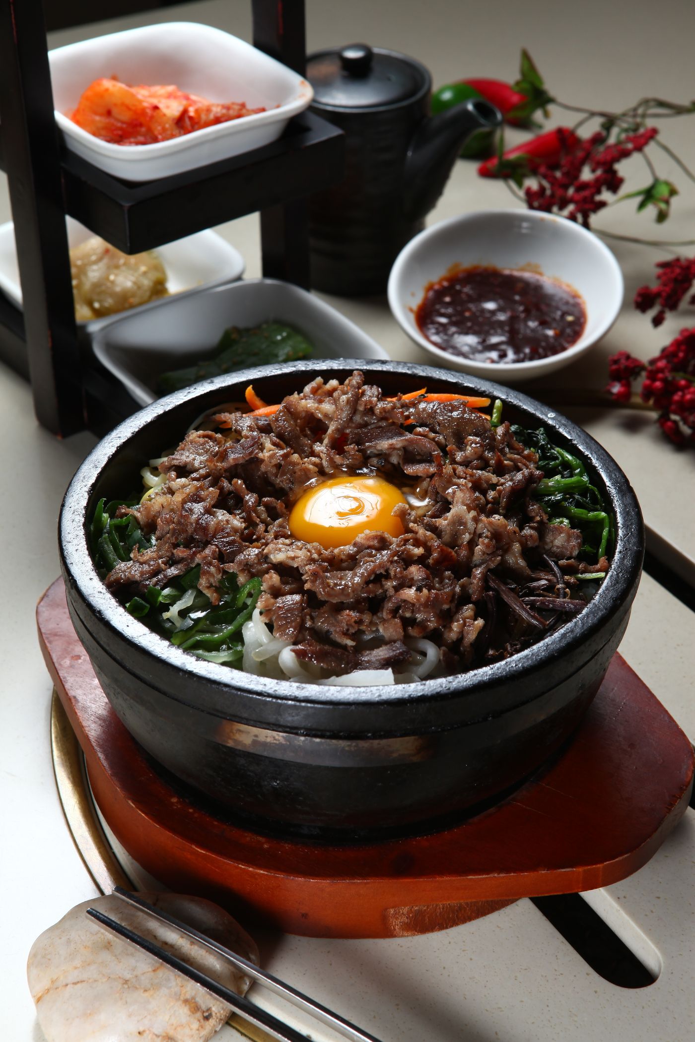 Stone bowl of bibimbap, still bubbling, with side dishes