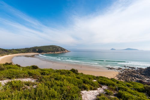 Scenic View Of Beach Under Blue And Cloudy Sky