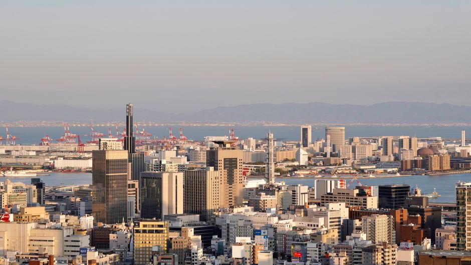 Panoramic view of a modern urban skyline with waterfront and skyscrapers at daylight.