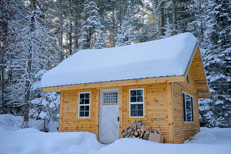 Snow Covered Wooden House Inside Forest