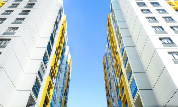 Low angle view of modern apartment buildings in Türkiye against a clear blue sky.