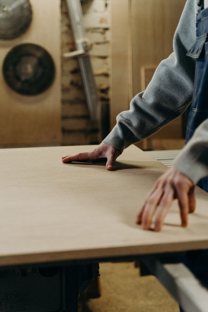 Close-up of a craftsman's hands fitting a wooden board