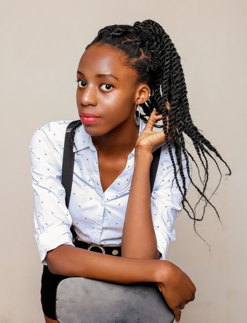 Free A studio portrait of a woman with braided hair wearing a white blouse and suspenders. Stock Photo