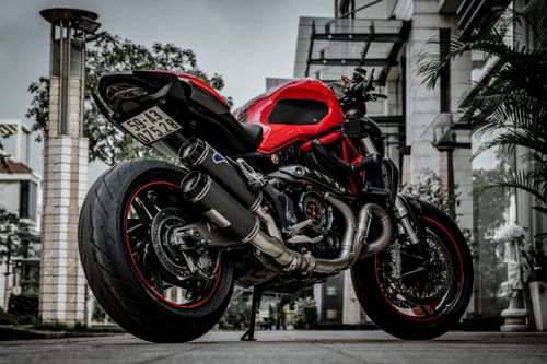 Free Close-up of a luxurious red sports motorcycle parked in a modern urban environment. Stock Photo