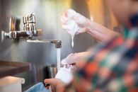 Person Pouring Water on Stainless Steel Faucet