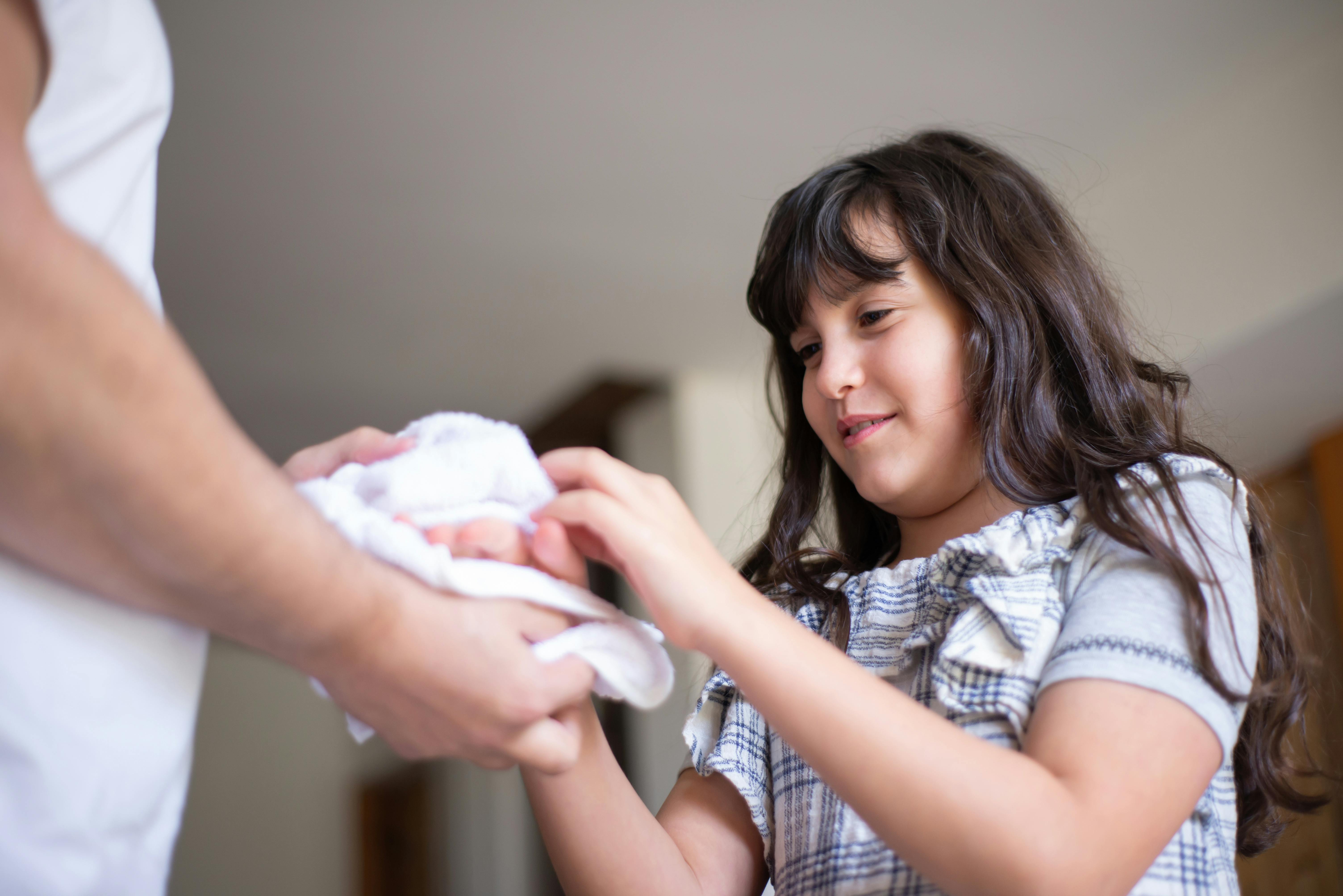 a girl wiping her hands using a face towel