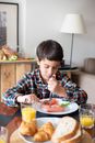 Boy in Plaid Shirt Cutting His Food