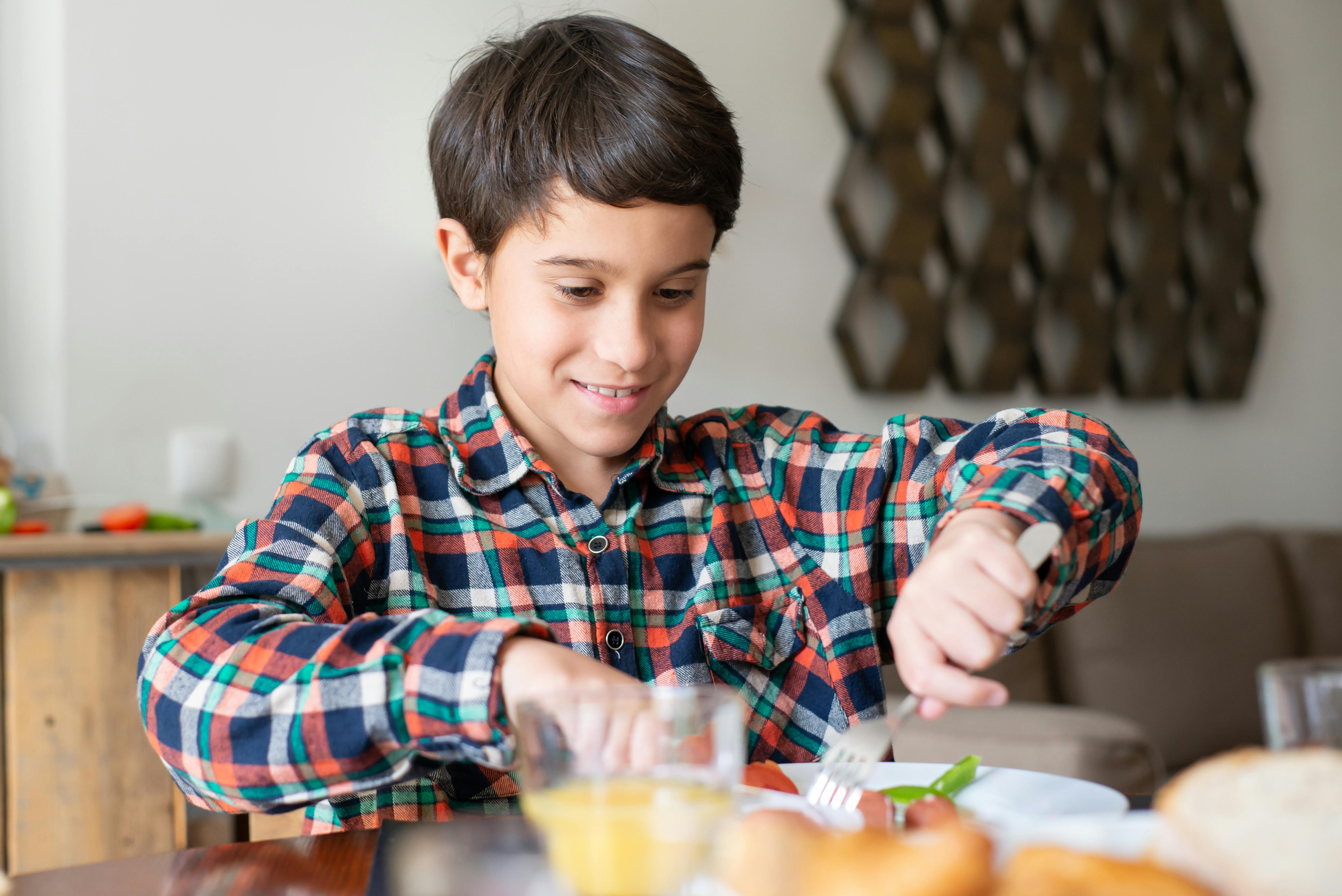 Happy young boy enjoying a nutritious breakfast at home with natural lighting.