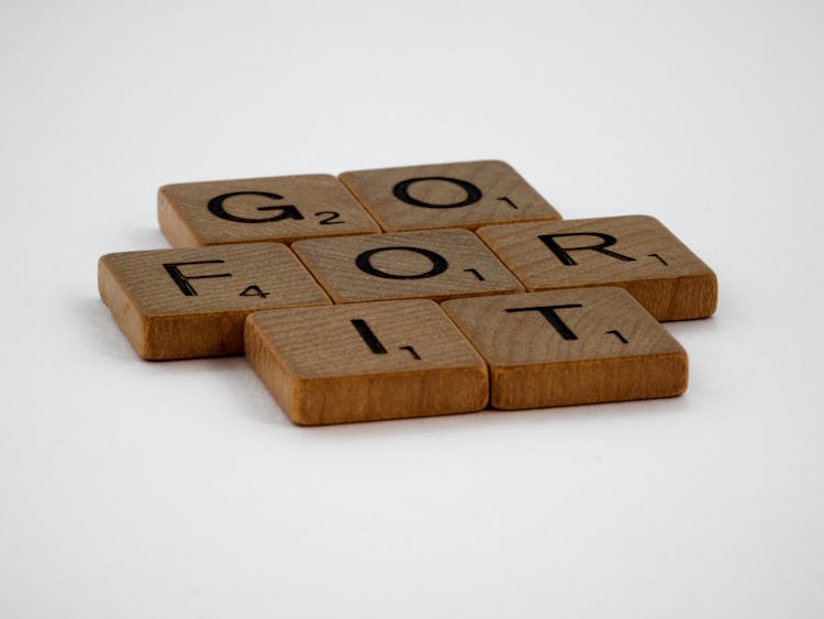 Close-Up Shot Of Scrabble Tiles On A White Surface