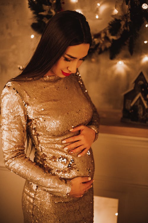 A Woman in Metallic Dress Holding Her Belly