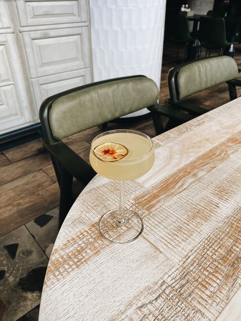 Close-up of a cocktail with a lime slice in a chic urban setting.