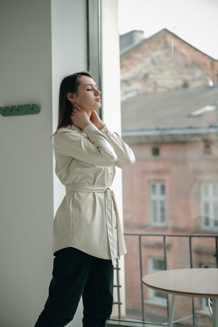 Woman Standing In Room Near Window And Table