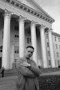 Cool man against old building with colonnade in city