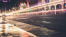 夜晚的城市街道充满活力，动态的灯光与现代化建筑交相辉映