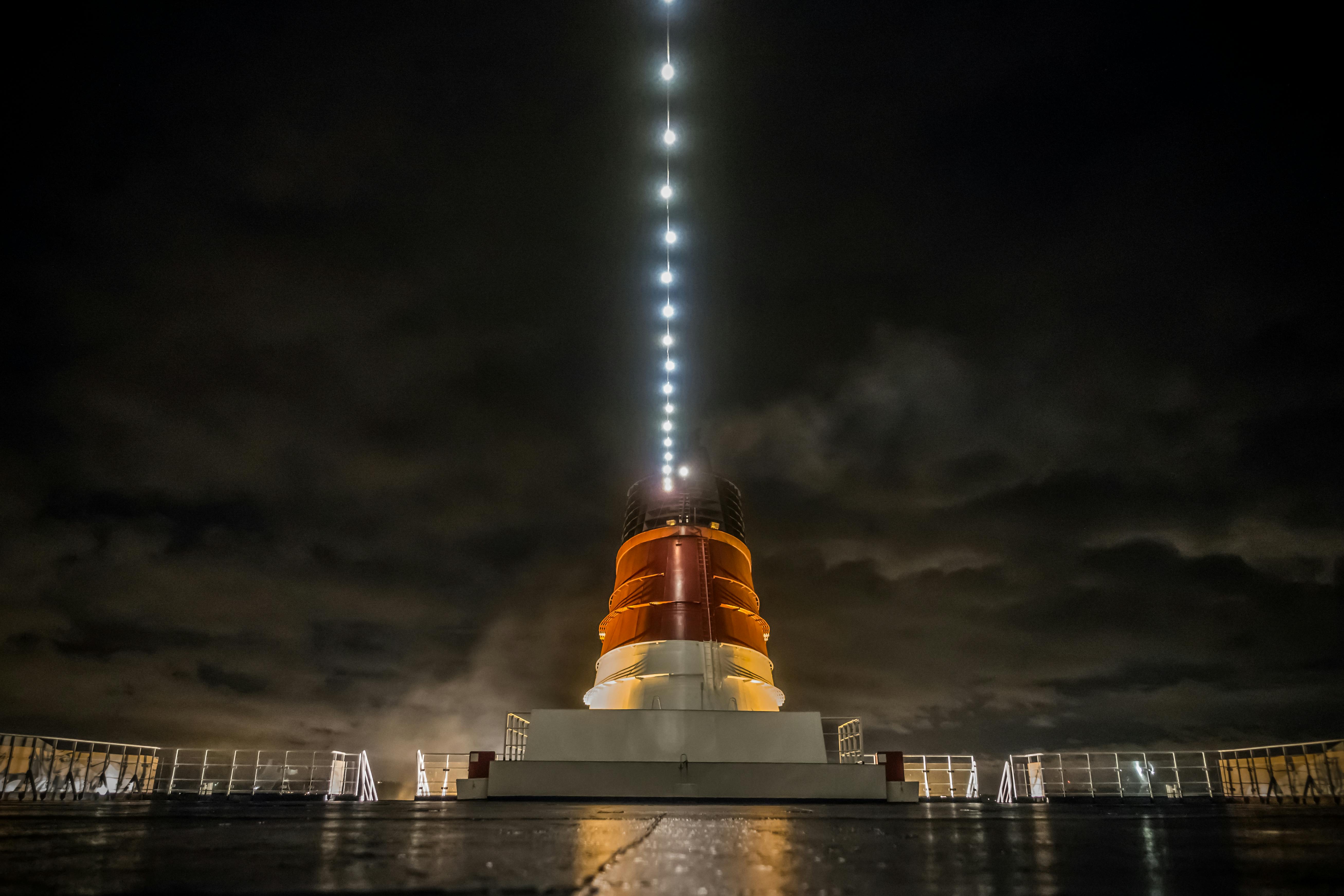 在赫尔辛基，一艘游轮的烟囱在阴云密布的夜空中明亮地闪耀