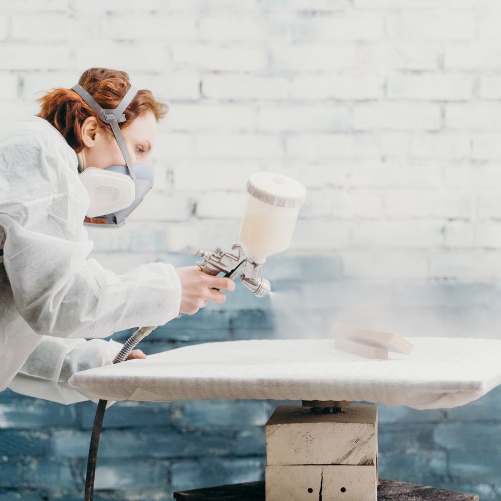 Specialist spraying a factory-smooth finish onto cabinet furniture
