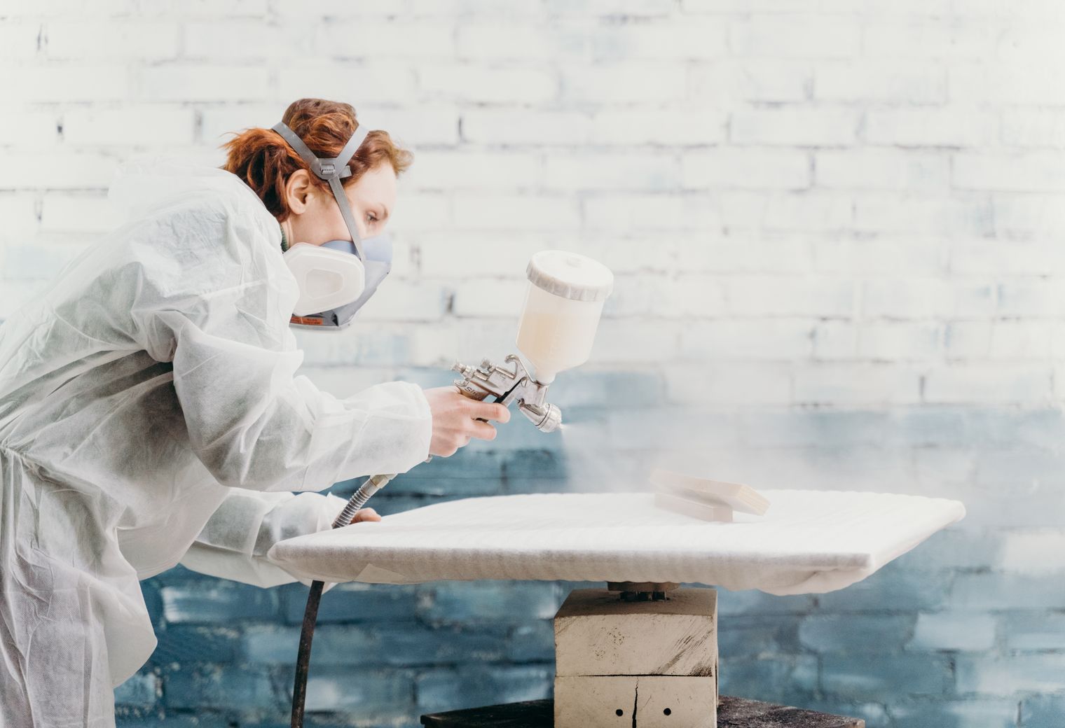 Specialist spraying a factory-smooth finish onto cabinet furniture