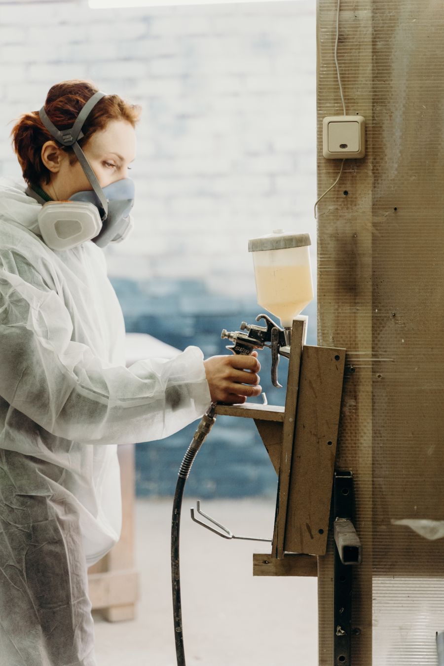 Technician in PPE preparing and stripping a surface