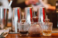 Clear Glass Perfume Bottle on Brown Wooden Table