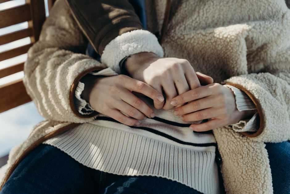 Close-up of two partners softly holding hands across a wooden table during a calm conversation Close-up of two partners softly holding hands across a wooden table during a calm conversation