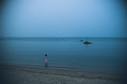 Photo of a Kid Walking at the Beach