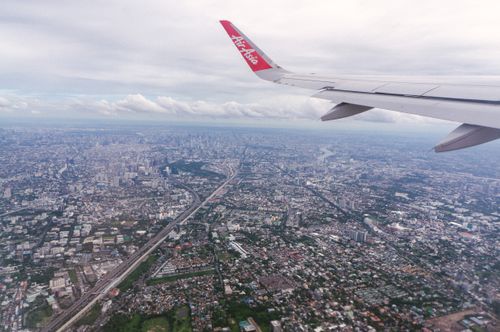 Free Scenic aerial view of Bangkok cityscape from an airplane window at daytime, showcasing urban sprawl. Stock Photo