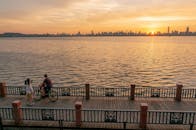 A Man Riding a Bicycle on the Wooden Dock During Golden Hour