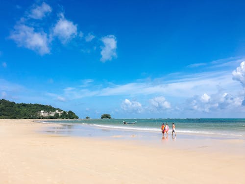 Free Beautiful tropical beach in Phuket, Thailand with blue skies, calm seas, and a serene atmosphere. Stock Photo