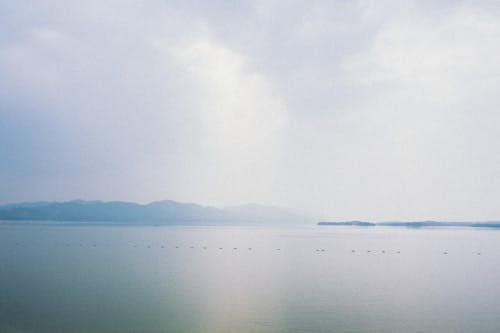 Body of Water Under White Sky