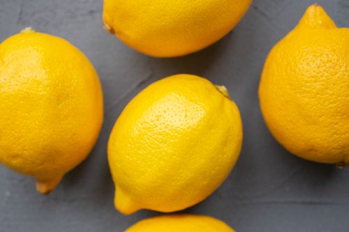 Free Top view of vibrant yellow lemons arranged on a dark surface, perfect for culinary themes. Stock Photo