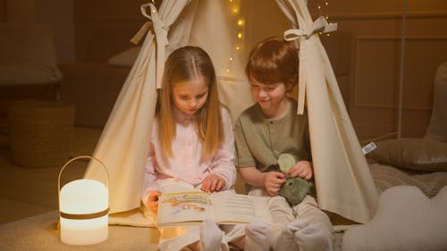 Free Children Reading a Book Inside a Room Stock Photo