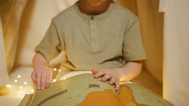 Close-Up Shot Of A Boy Holding A Book
