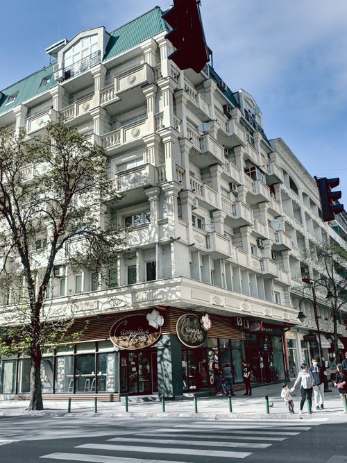 Free Charming corner building with classic architecture on a sunny urban street. Stock Photo