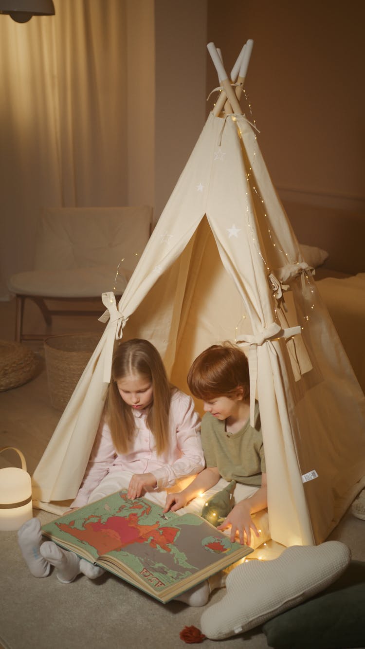 Photograph Of Siblings Looking At A Map