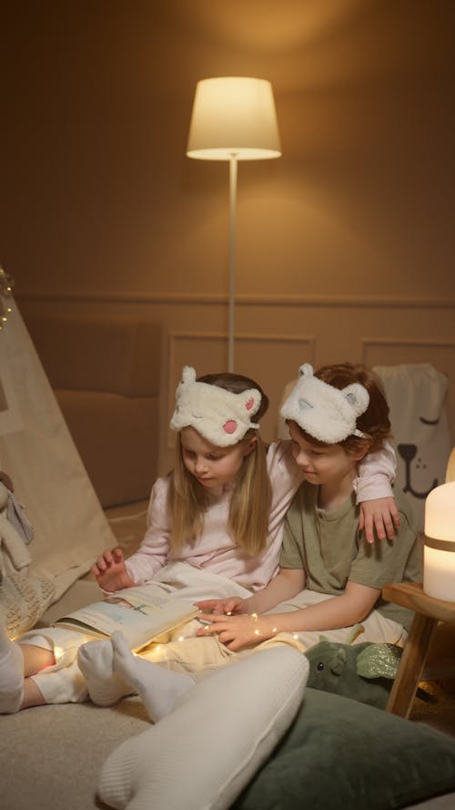 Free Siblings Having a Bedtime Story Stock Photo