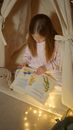 A Girl Reading a Book for a Bedtime Story while in an Indoor Tent