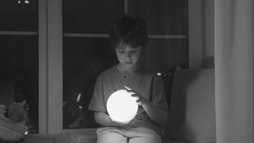 Boy Holding A Glowing Round Lamp