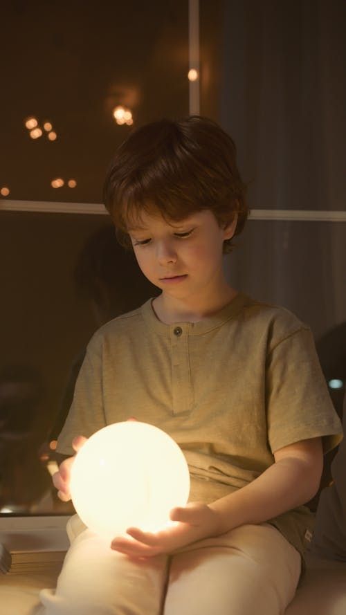 Boy Holding An Illuminated Round Lamp