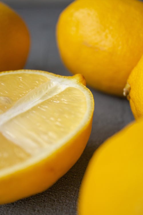 Free High angle closeup of fresh ripe bright yellow lemons placed on gray table Stock Photo