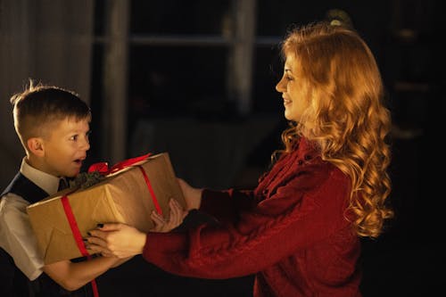 Photo of a Mother Giving a Gift to Her Son